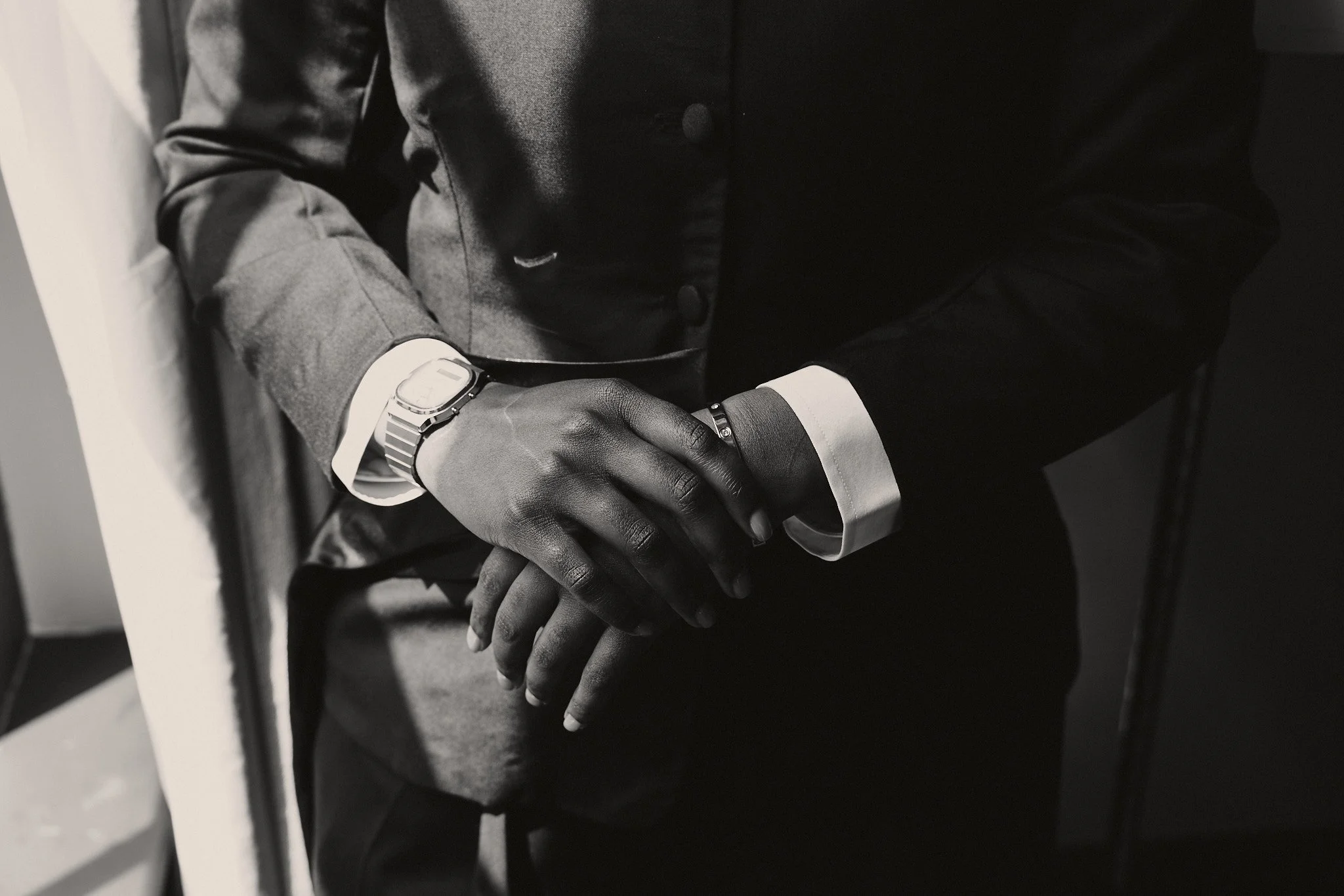  Hands clasped before the ceremony, cuffs and a watch 