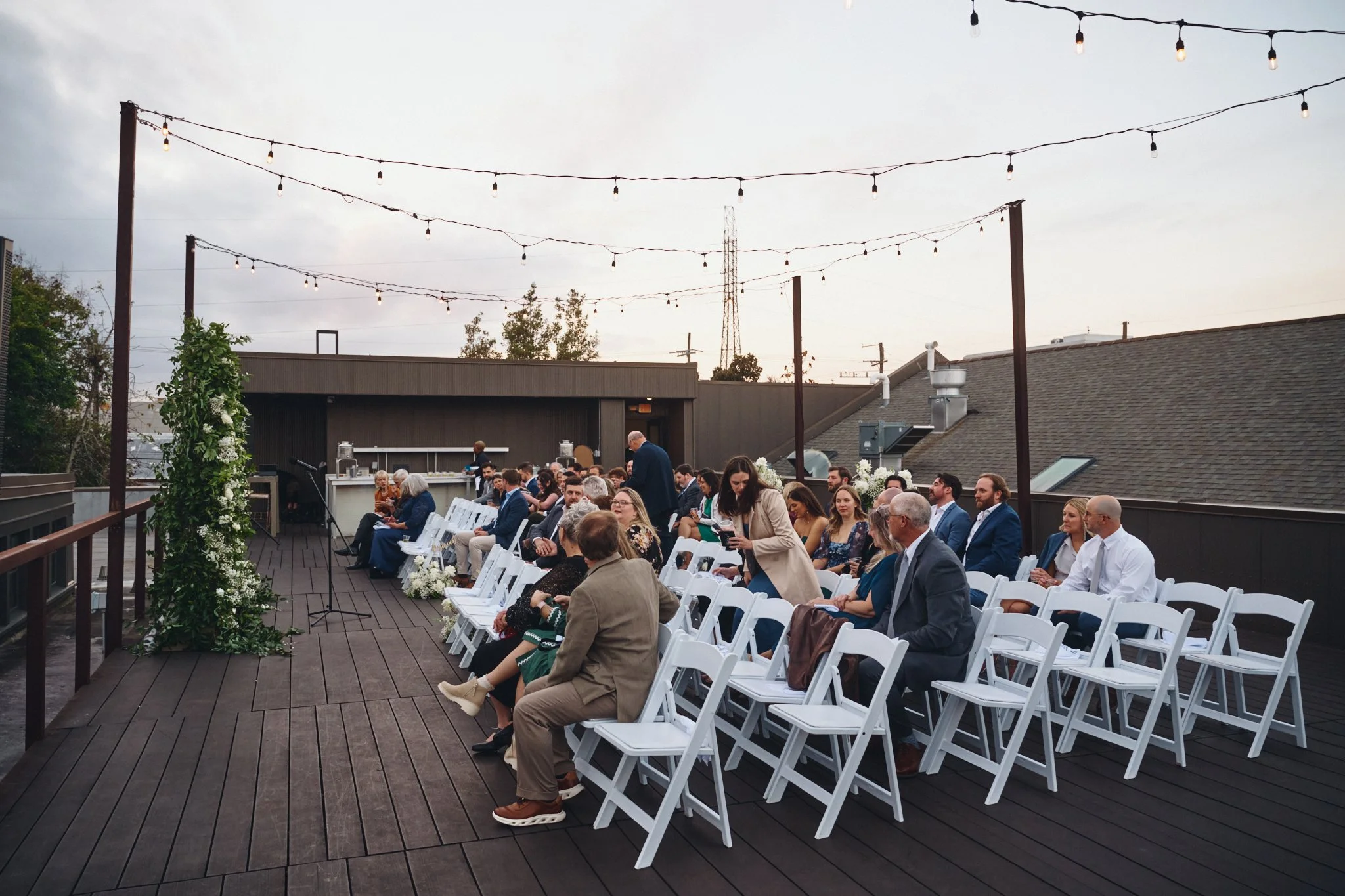 Guests taking their seats on the rooftop deck under string lights before a ceremony at Capulet in New Orleans 