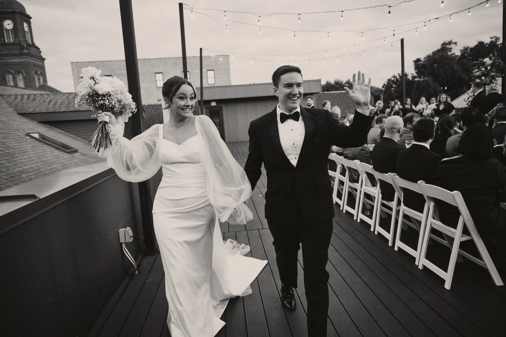  A bride and groom cheering as they come back down the rooftop aisle at Capulet in New Orleans 