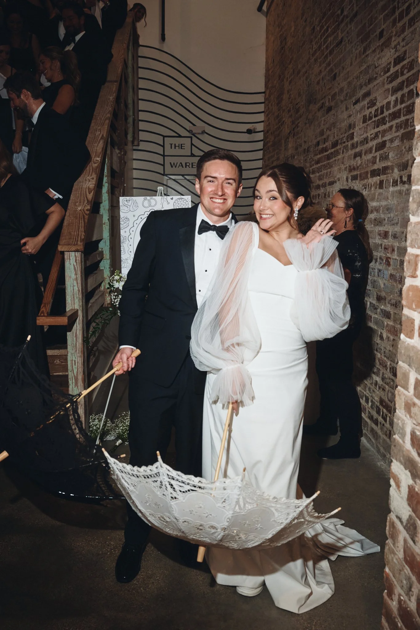  A bride and groom with second line parasols against the exposed brick wall at Capulet in New Orleans 