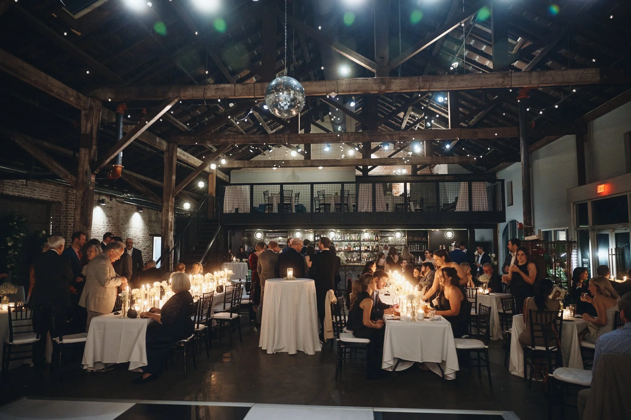  The warehouse reception hall with timber trusses, mezzanine bar and disco ball at Capulet in New Orleans 