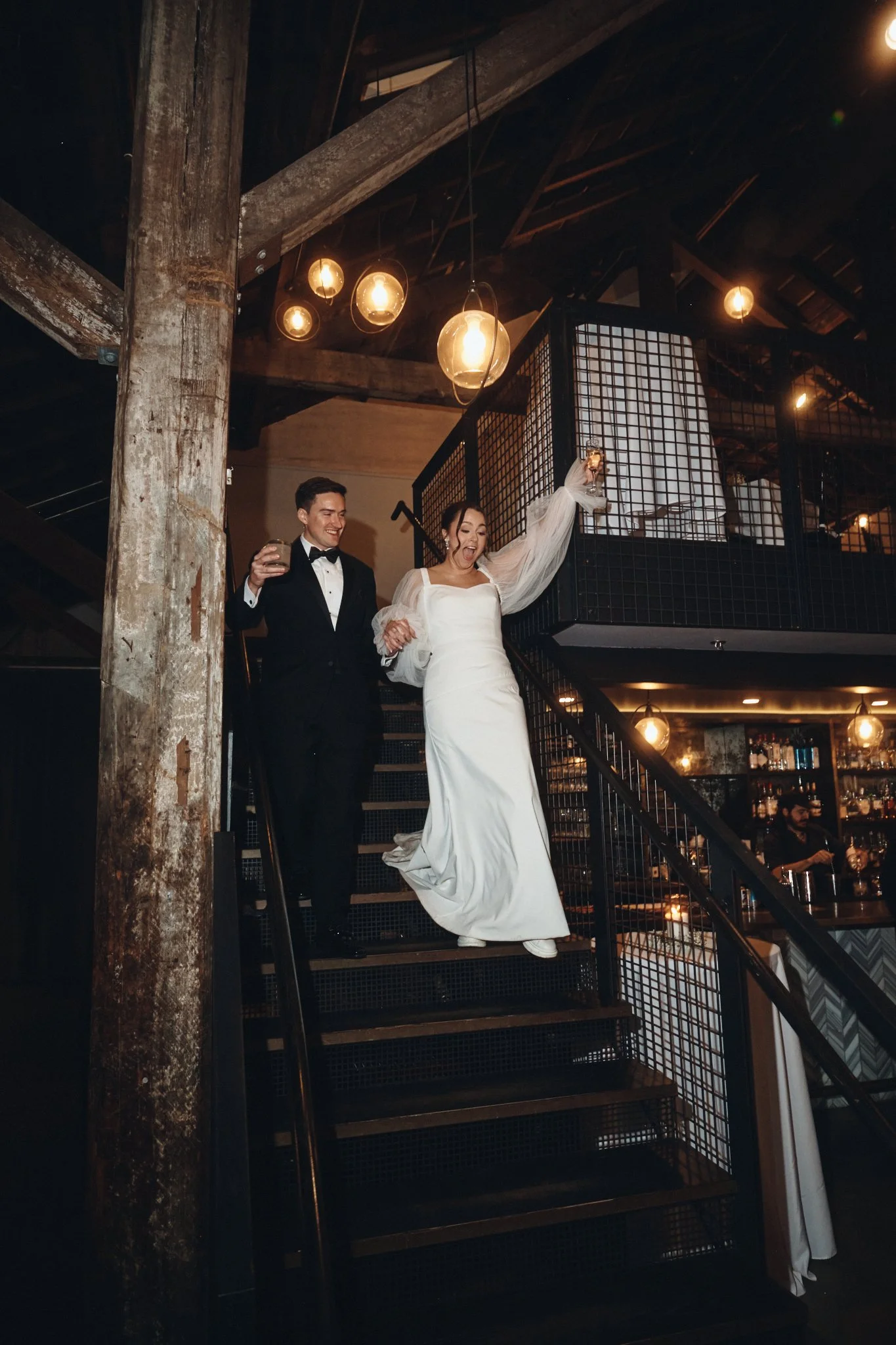  A bride and groom coming down the warehouse stairs into their reception at Capulet in New Orleans 