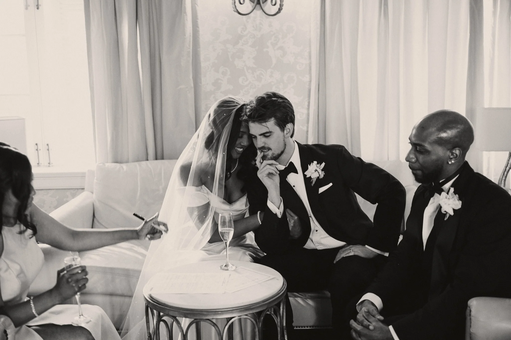 A bride and groom sitting with friends during a wedding reception at Marche in New Orleans