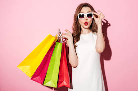 Satisfied shopper holding many shopping bags and wearing sunglasses