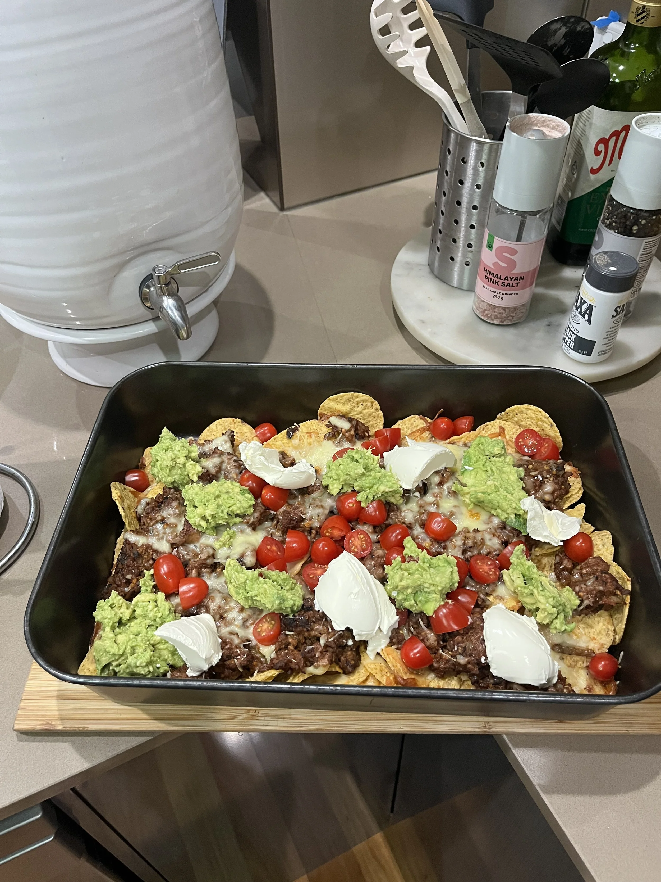 Homemade beef nachos with guacamole, tomatoes and sour cream.