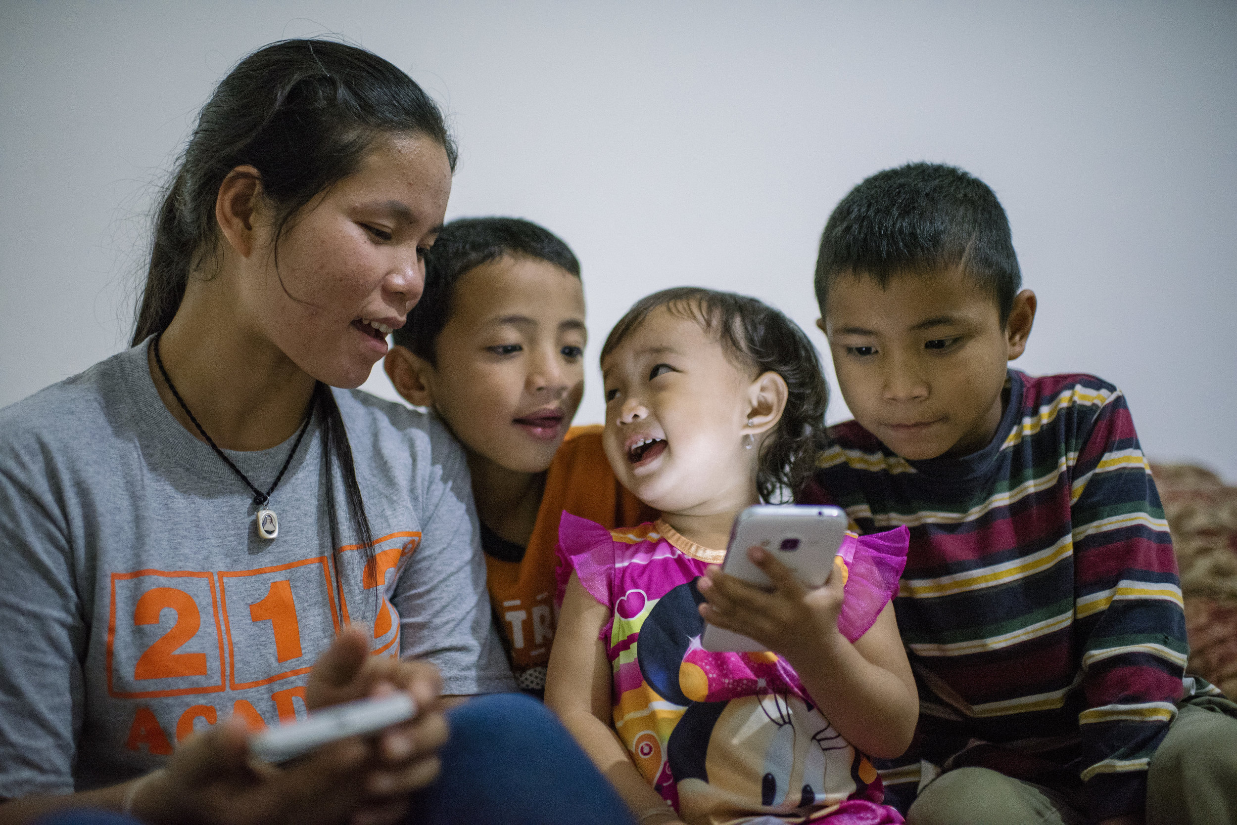  Phones play an important part in the kid's lives. It's a way to connect with their past culture, and also learn about their new culture. From left, Pray Moe, 24, Ti Reh, 8, Nga Meh, 2, and Reh Reh, 9, listen to one of their favorite songs, "I'm A Gu