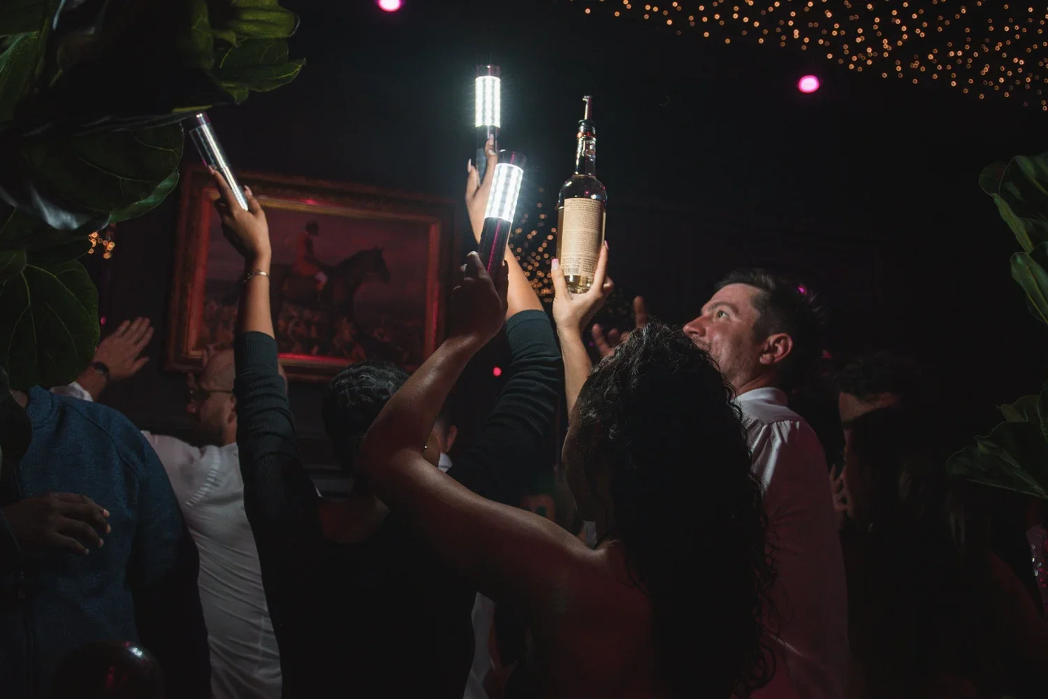 Bottle service celebration with raised lights and cheers on the dance floor at Fox on John.