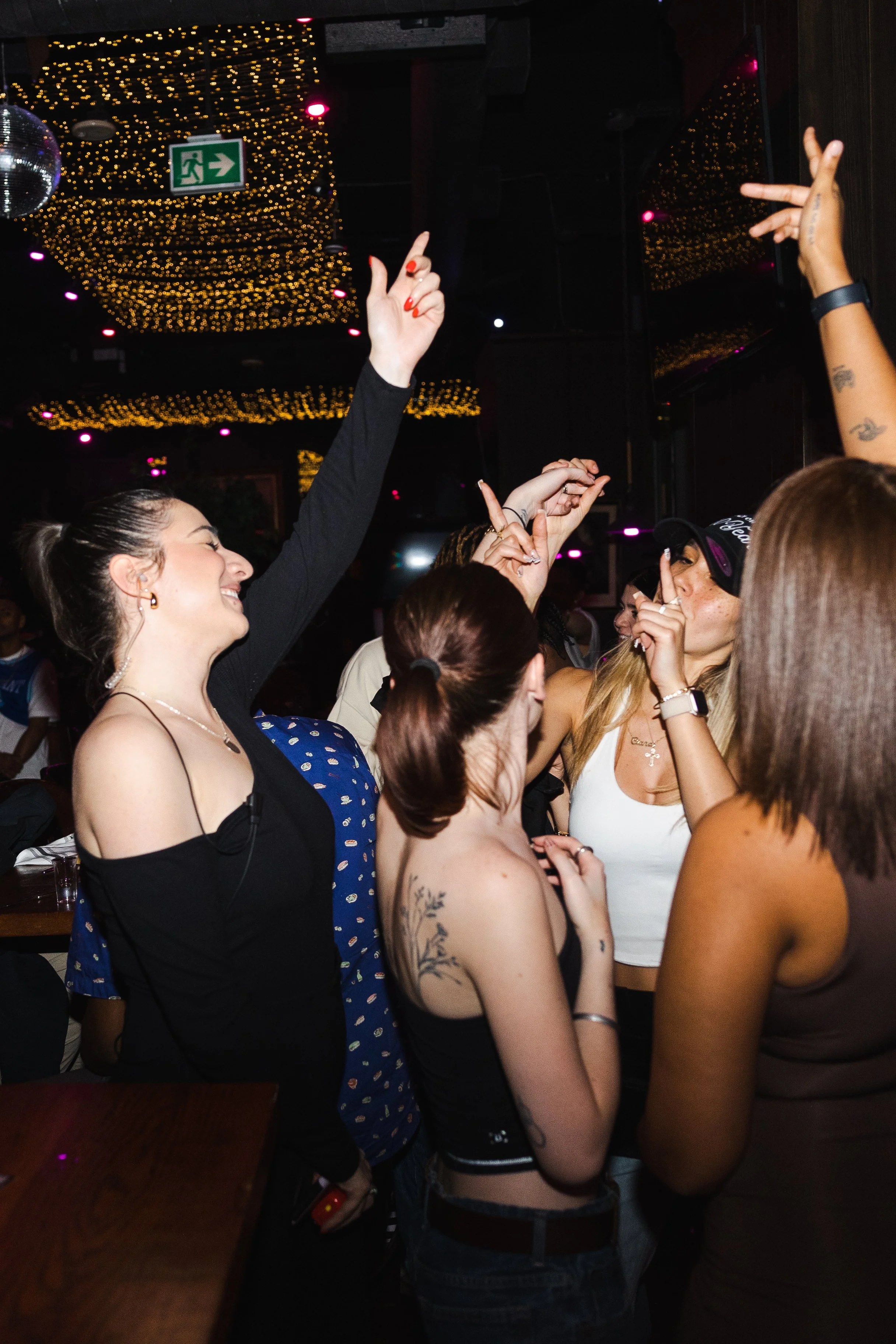 Group of friends dancing under colourful lights during a late-night party at Fox on John.