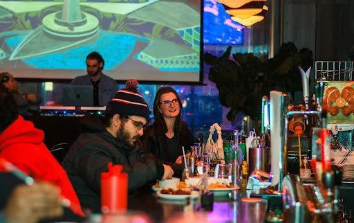 Friends enjoying drinks and game night energy inside Fox on John sports bar in downtown Toronto