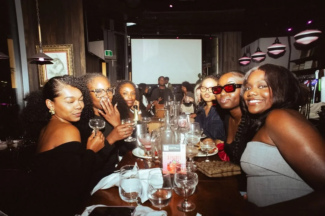 Guests celebrating together at Fox on John with cocktails, music, and a vibrant group dining atmosphere.