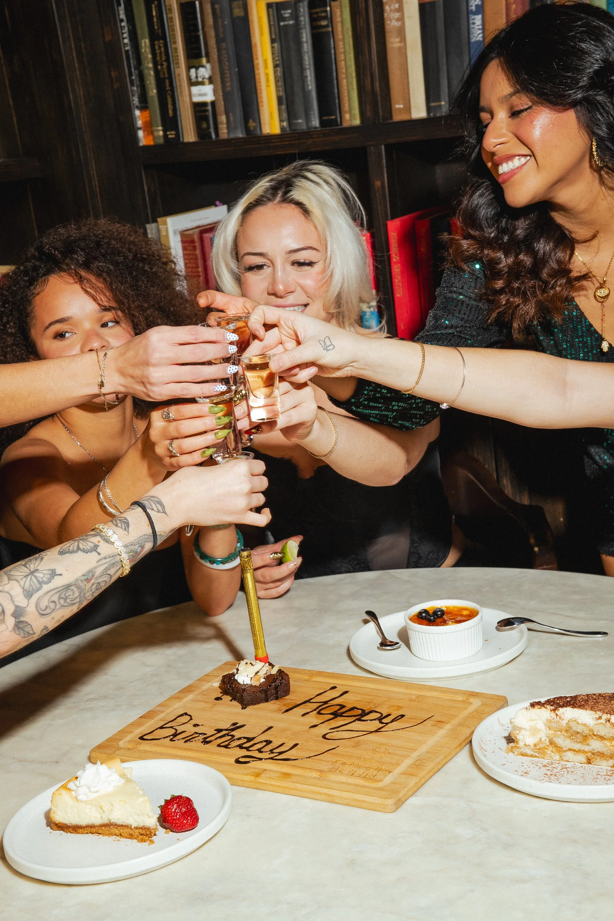 Decorative ceramic bottle with blue floral patterns and a glass of clear liquid on a wooden surface.