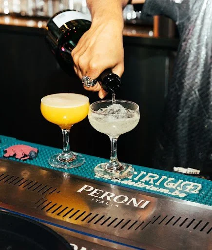 Bartender pouring fresh cocktails behind the bar at Fox on John in downtown Toronto.