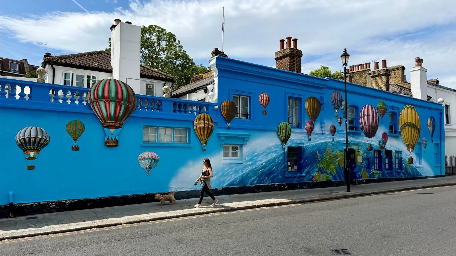 This year&rsquo;s much anticipated summer mural on the exterior of the Chelsea Arts Club, Old Church Street is underway and as ever it&rsquo;s absolutely brilliant. 
The 3-D hot air balloons are incredible. What do you know about it? 
We&rsquo;d love