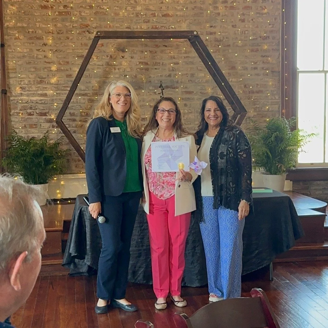 Lindy Beaty, Ellis County DA, receiving her Pinwheel Certificate with Leslie Deen & Cammy Jackson