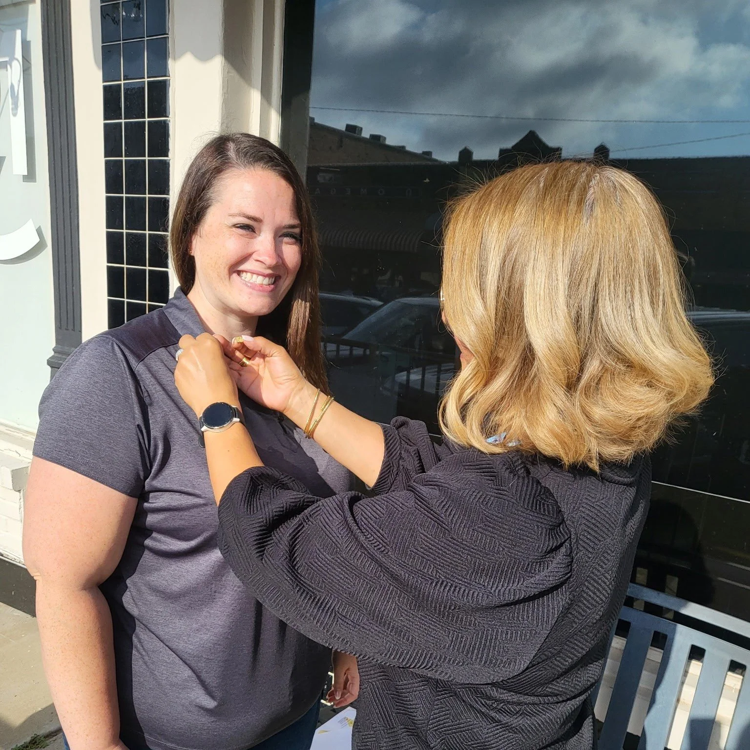 Liz Calvo with Heaven Woolverton of the Knight Family Foundation, receiving a Pinwheel Pin on behalf of the foundation.