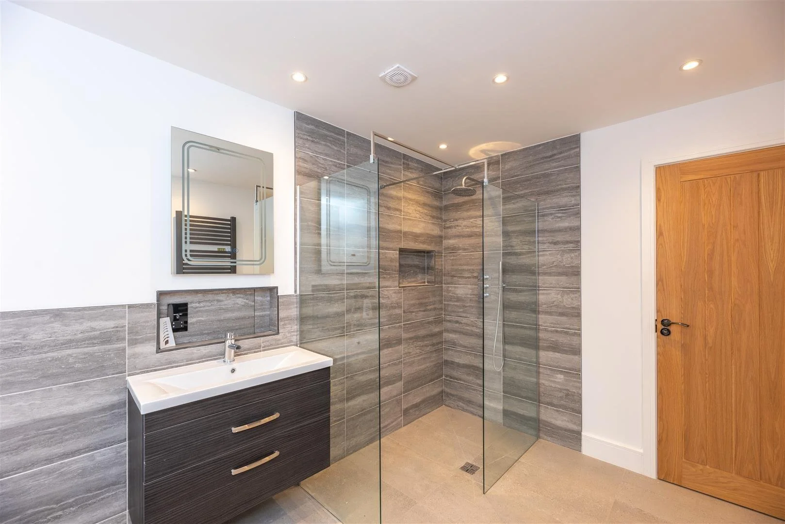 large luxury bathroom with wall mounted sink and walk in shower
