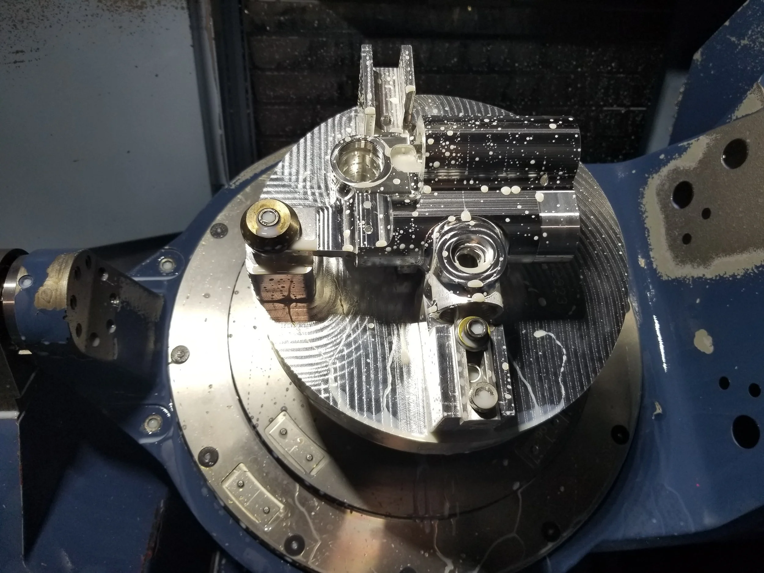 The 6th side was unable to be reached during the first main machining operation. The use of custom fixtures are built as needed to complete parts.