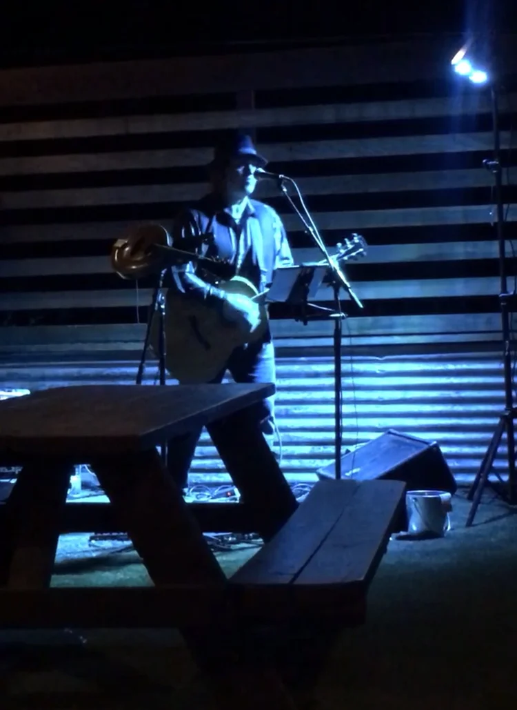 Guitarist playing live music on the patio stage at Gander Taphouse
