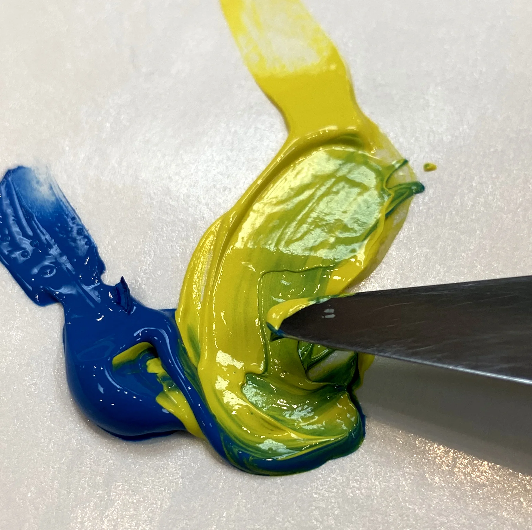 Here I am mixing a yellow with a blue to make a new color of green.