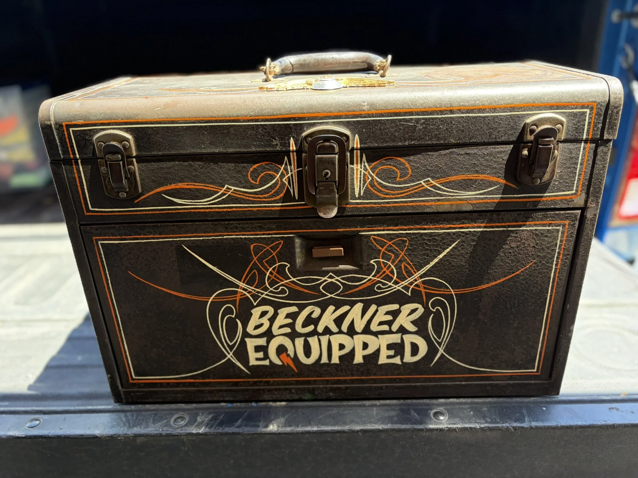 Orange and ivory pinstriping along with a silver and gold leaf flying eyeball on a toolbox by Matt Beckner.
