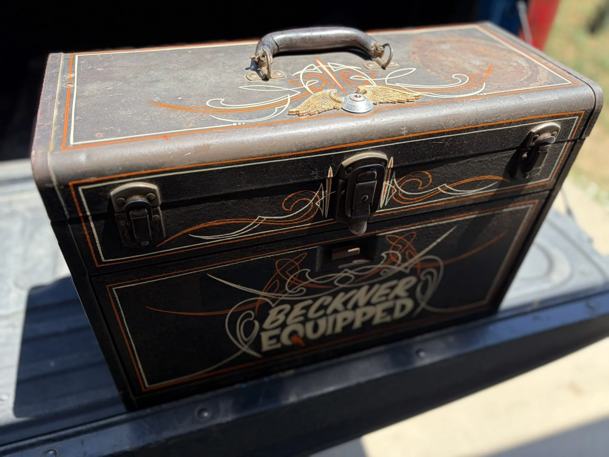 Orange and ivory pinstriping along with a silver and gold leaf flying eyeball on a toolbox by Matt Beckner.