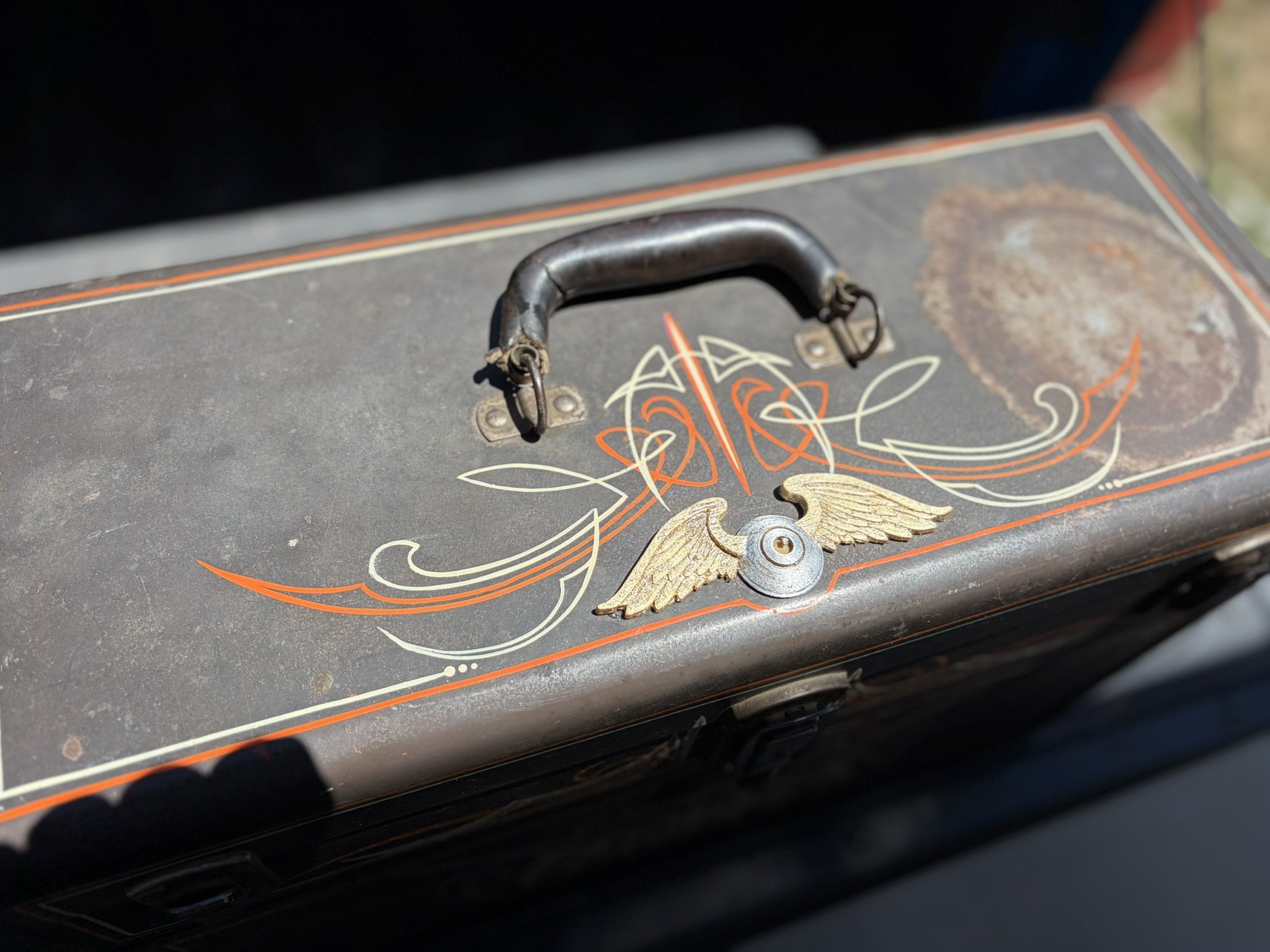 Orange and ivory pinstriping along with a silver and gold leaf flying eyeball on a toolbox by Matt Beckner.