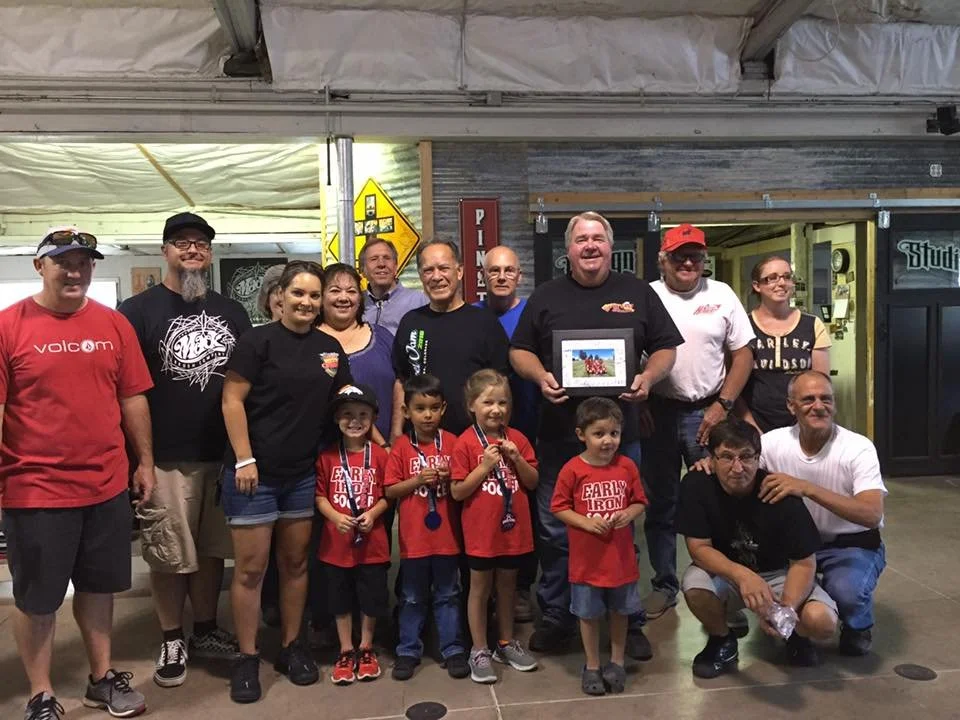 Early Iron club members posing with their sponsored little league team. 2016