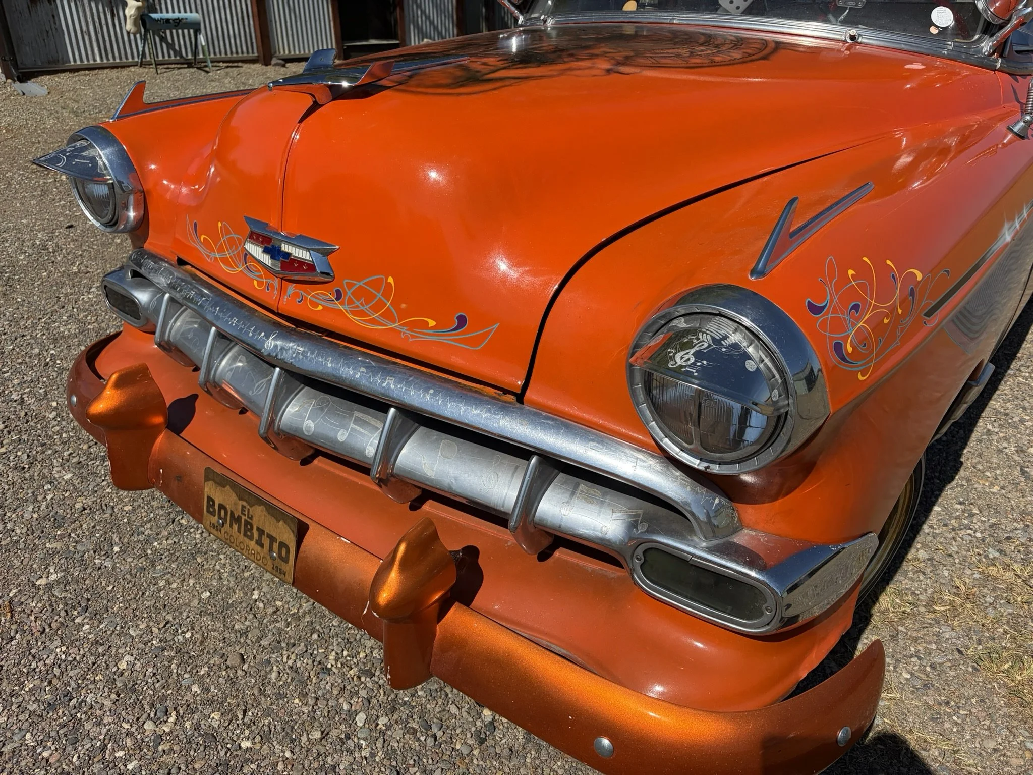 Orange lowrider front clip with turquoise, purple, and chrome yellow pinstriping by Matt Beckner.