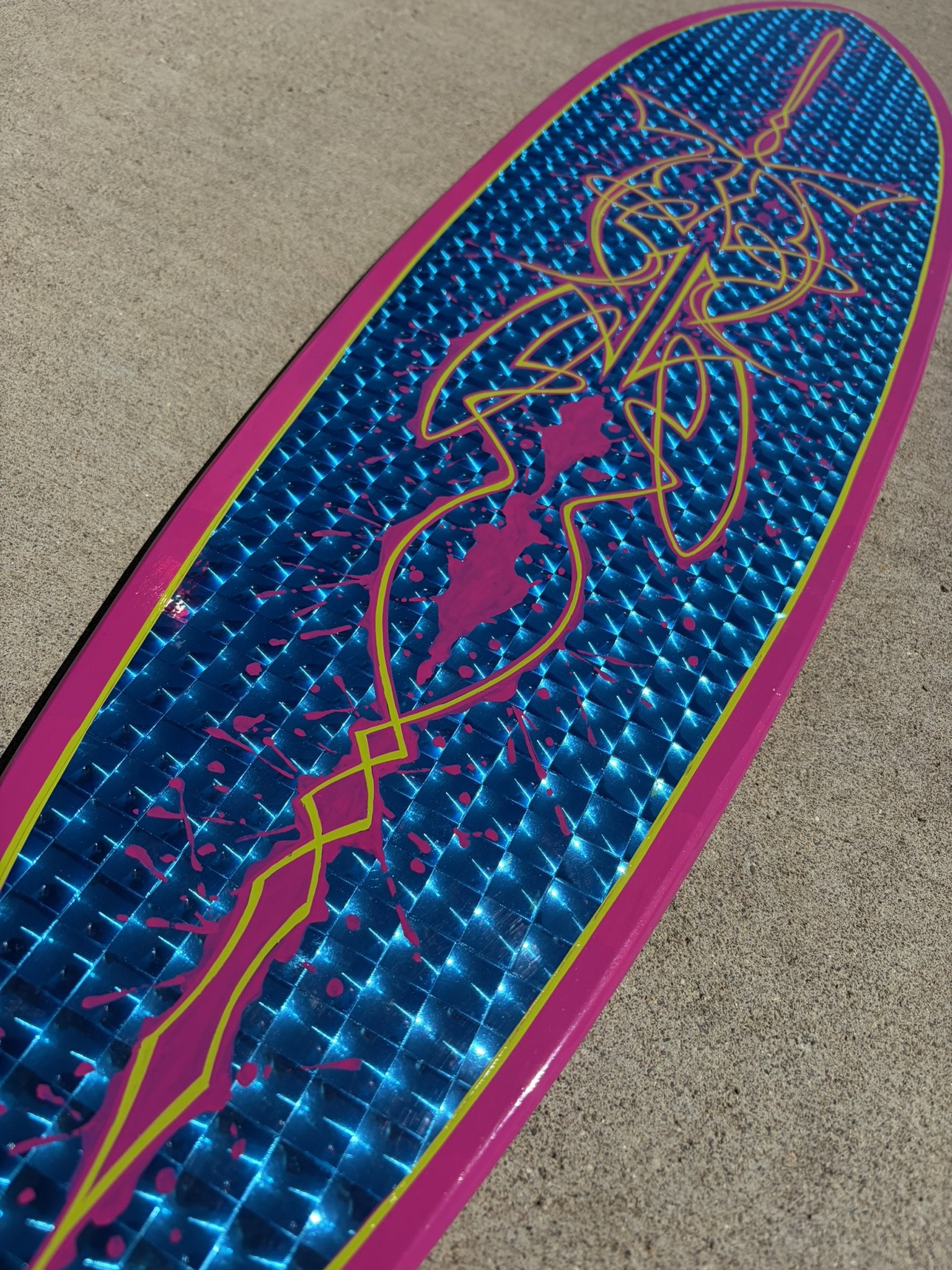 Close-up of a Pintail longboard with blue, prismatic background topped off with magenta and lime green pinstriping. Painted by Matt Beckner.