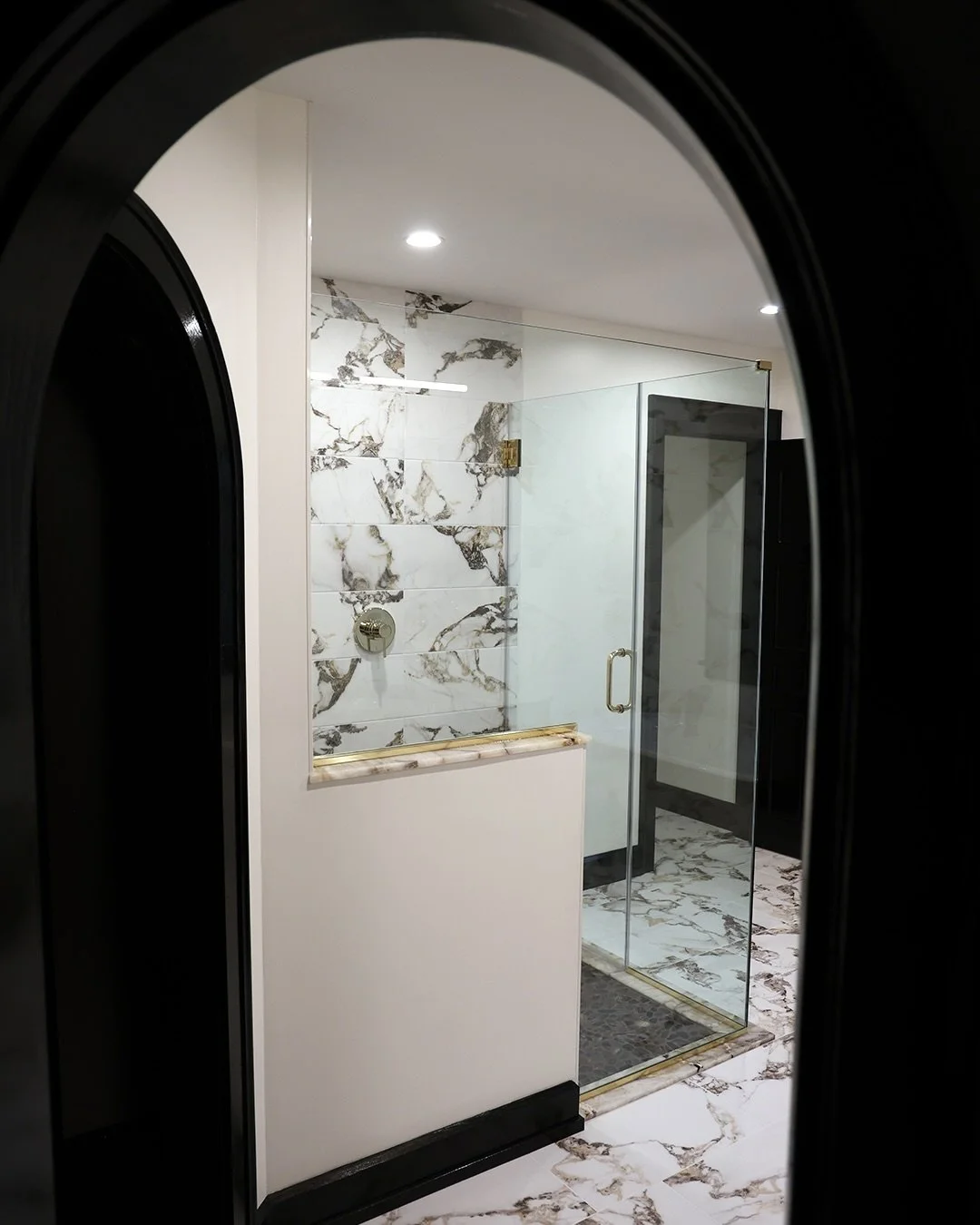 Bold black trim, brass and stone made this Orchard Park bathroom renovation timeless. Plus, who doesn&rsquo;t love a good claw foot? 🛁 #construction #bathroominspiration #clawfoottub