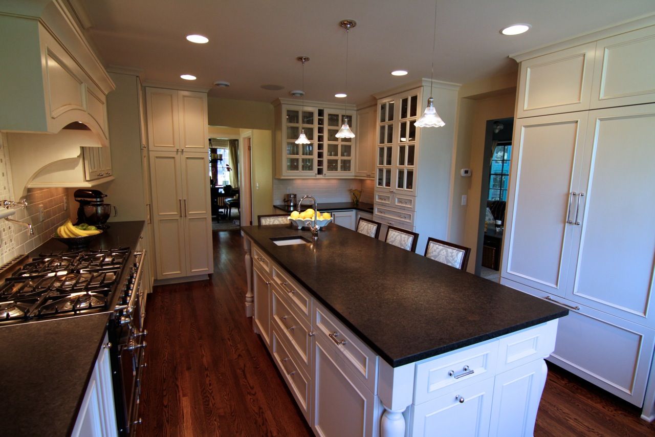 Kitchen remodel with large center island, wood floors, plenty of storage, hidden fridge, and new back splash.