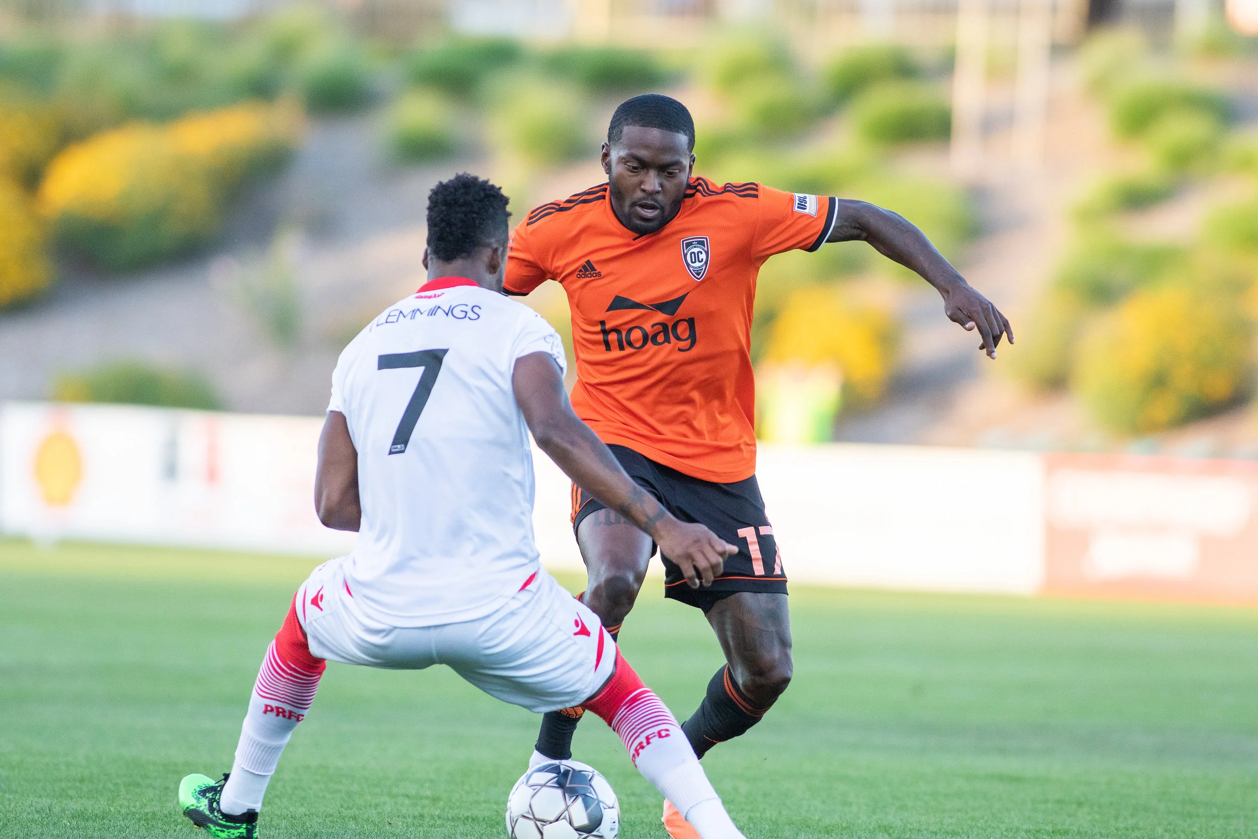 Orange County SC’s Darwin Jones looks to dribble past Phoenix Rising FC’s Junior Flemmings in their 2-1 victory on Saturday night. | Photo courtesy of Orange County SC (Liza Rosales)