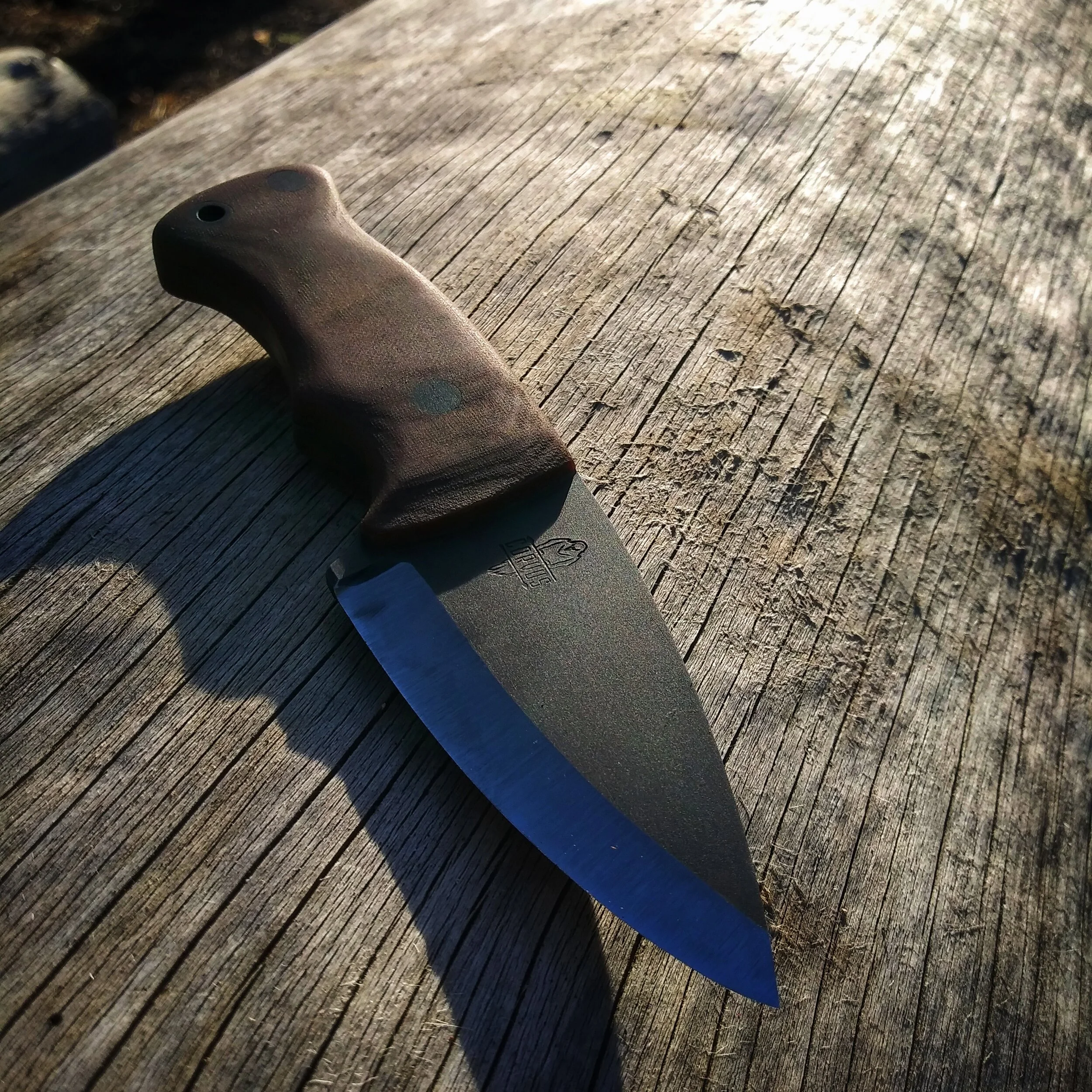 A knife resting on a wooden surface.