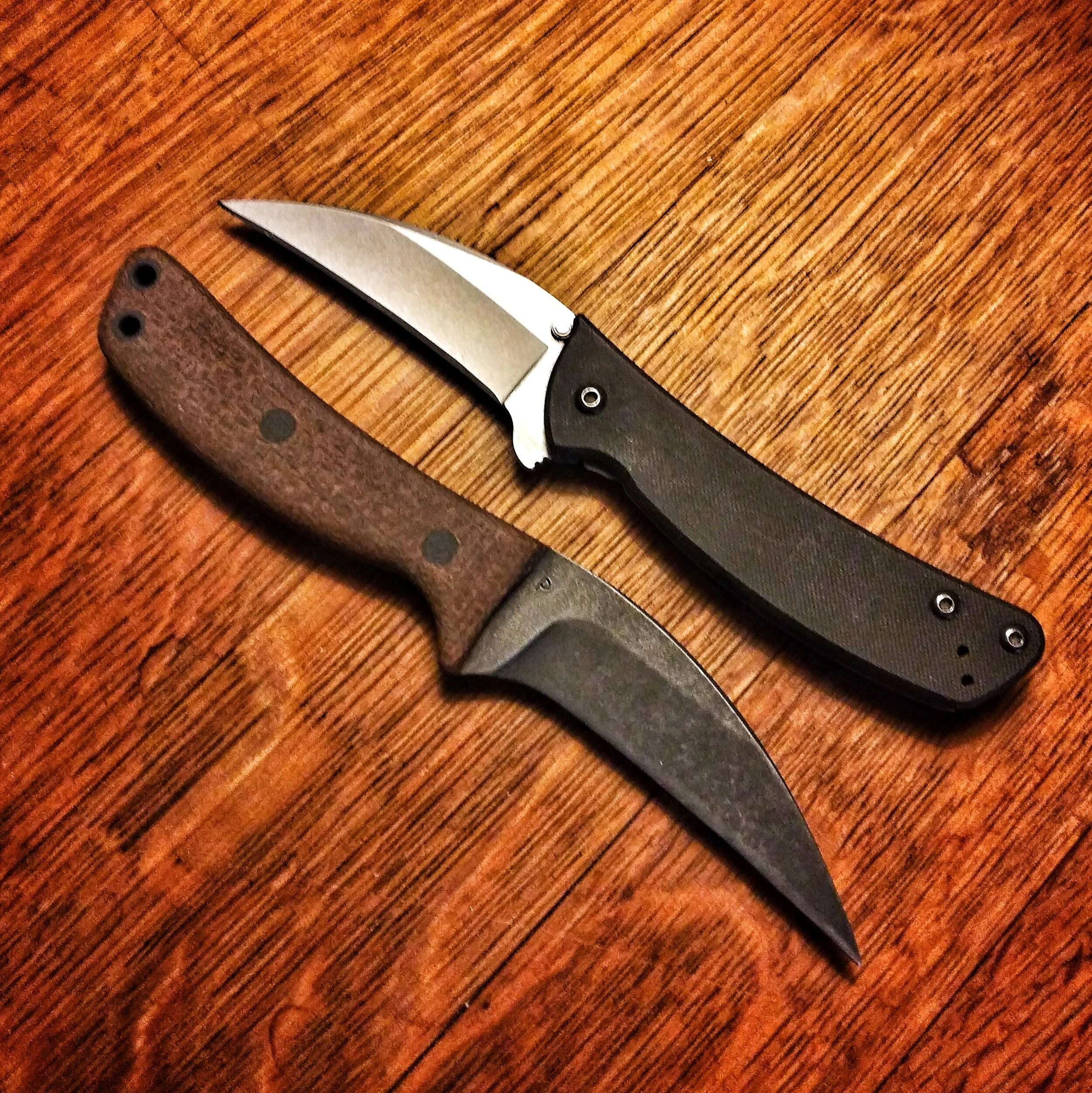 Two knifes laid side by side facing opposite directions.