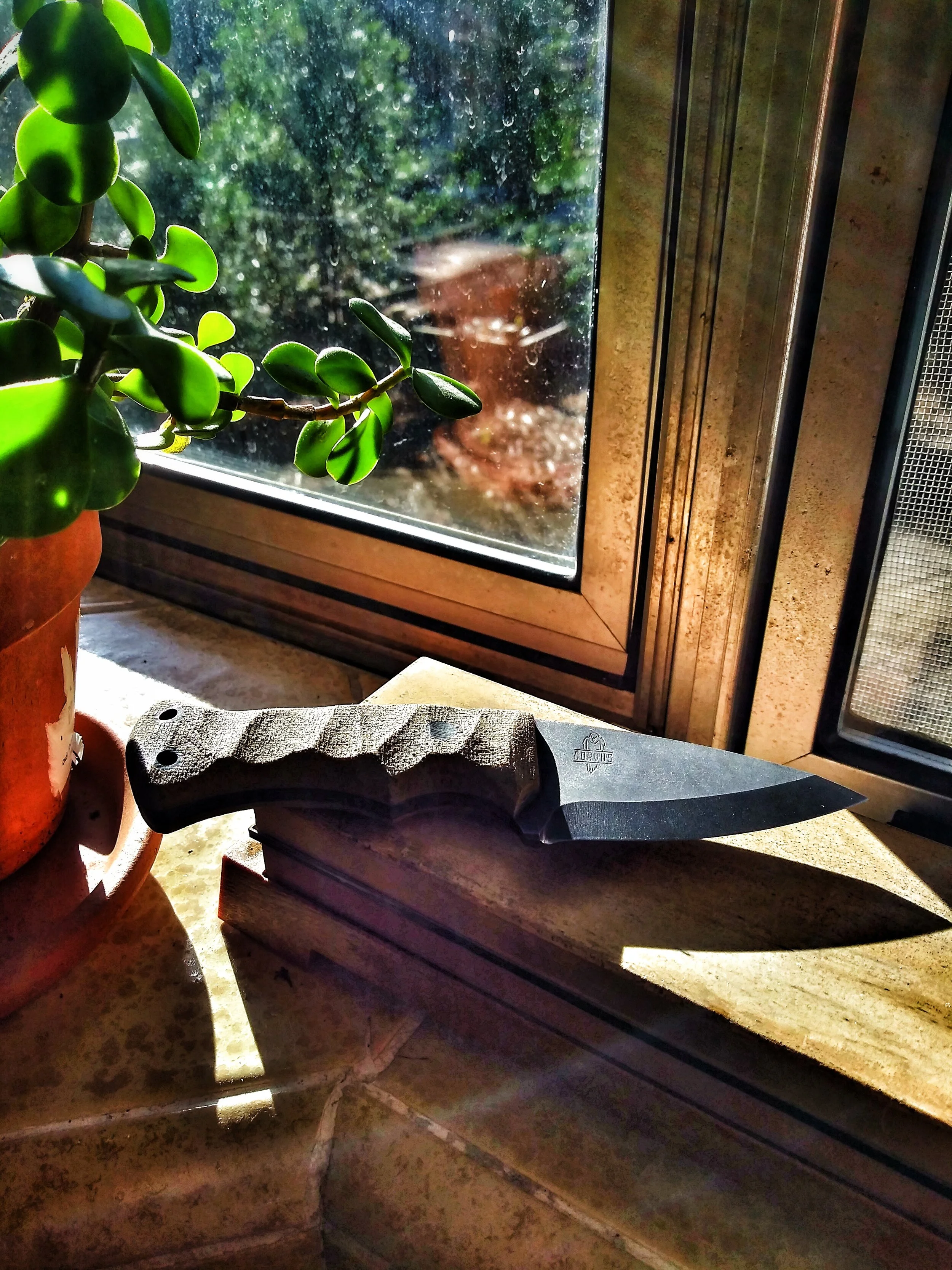 A knife laying on a windowsill.