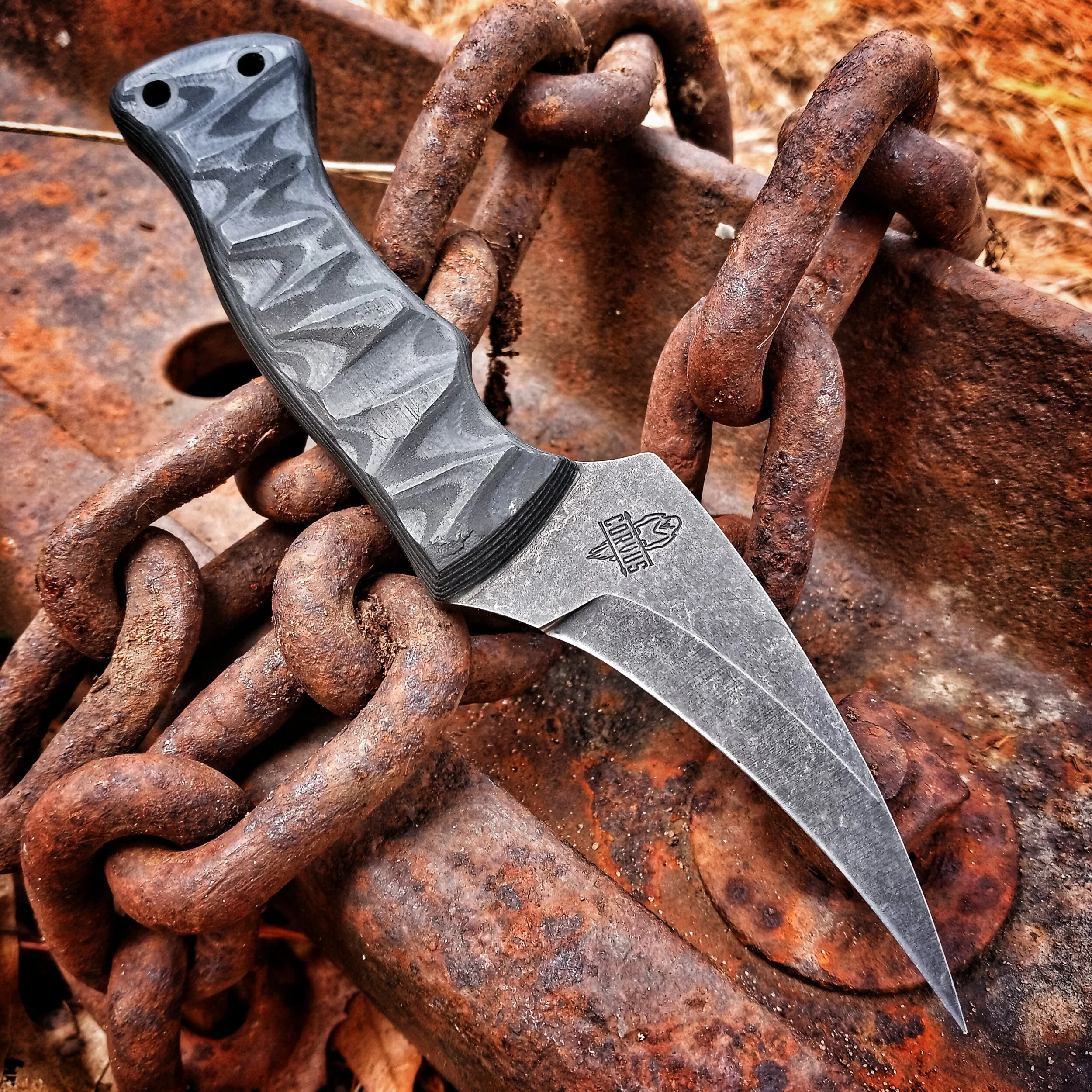 A knife resting on top of a large chain.