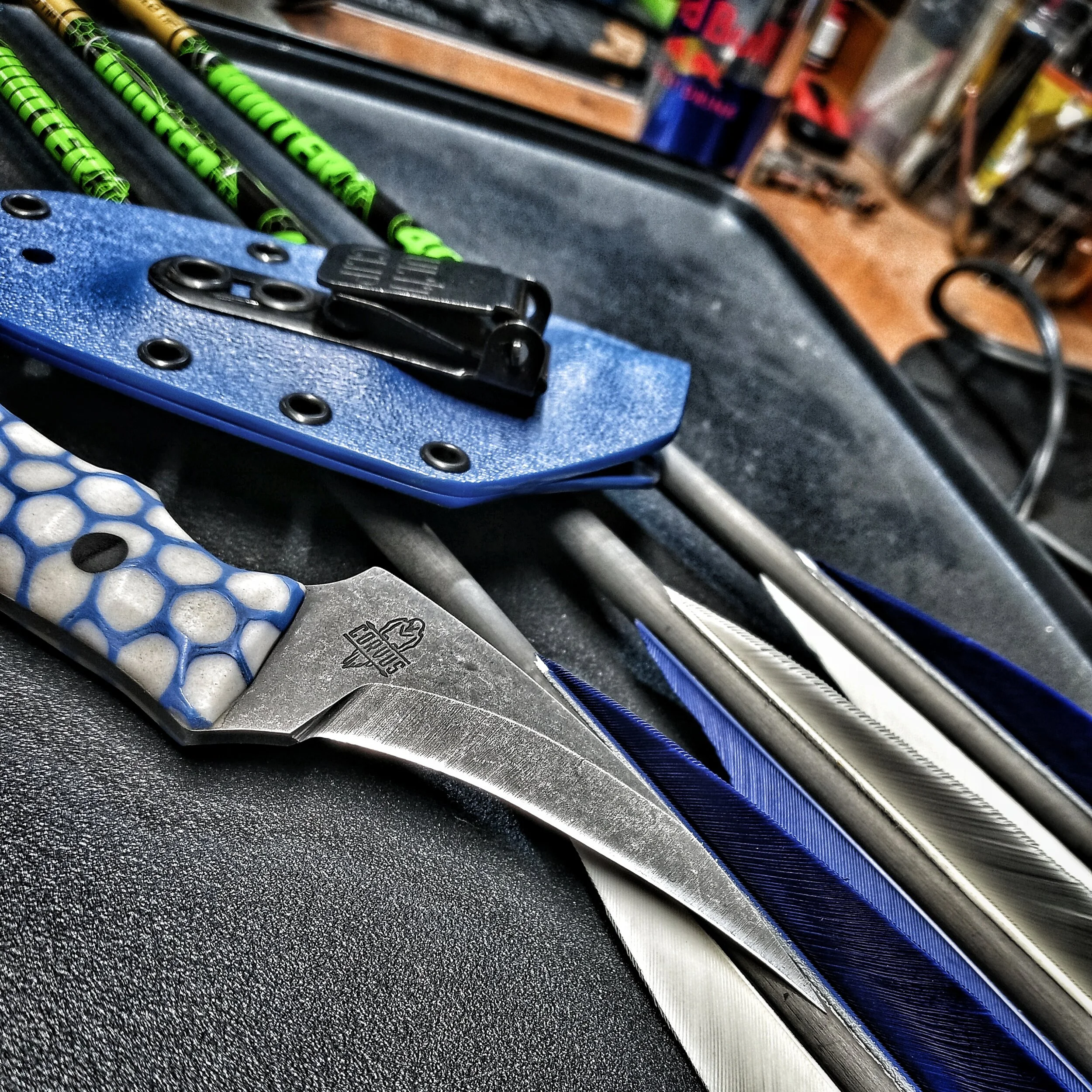 A knife and its sheath resting on some arrows.