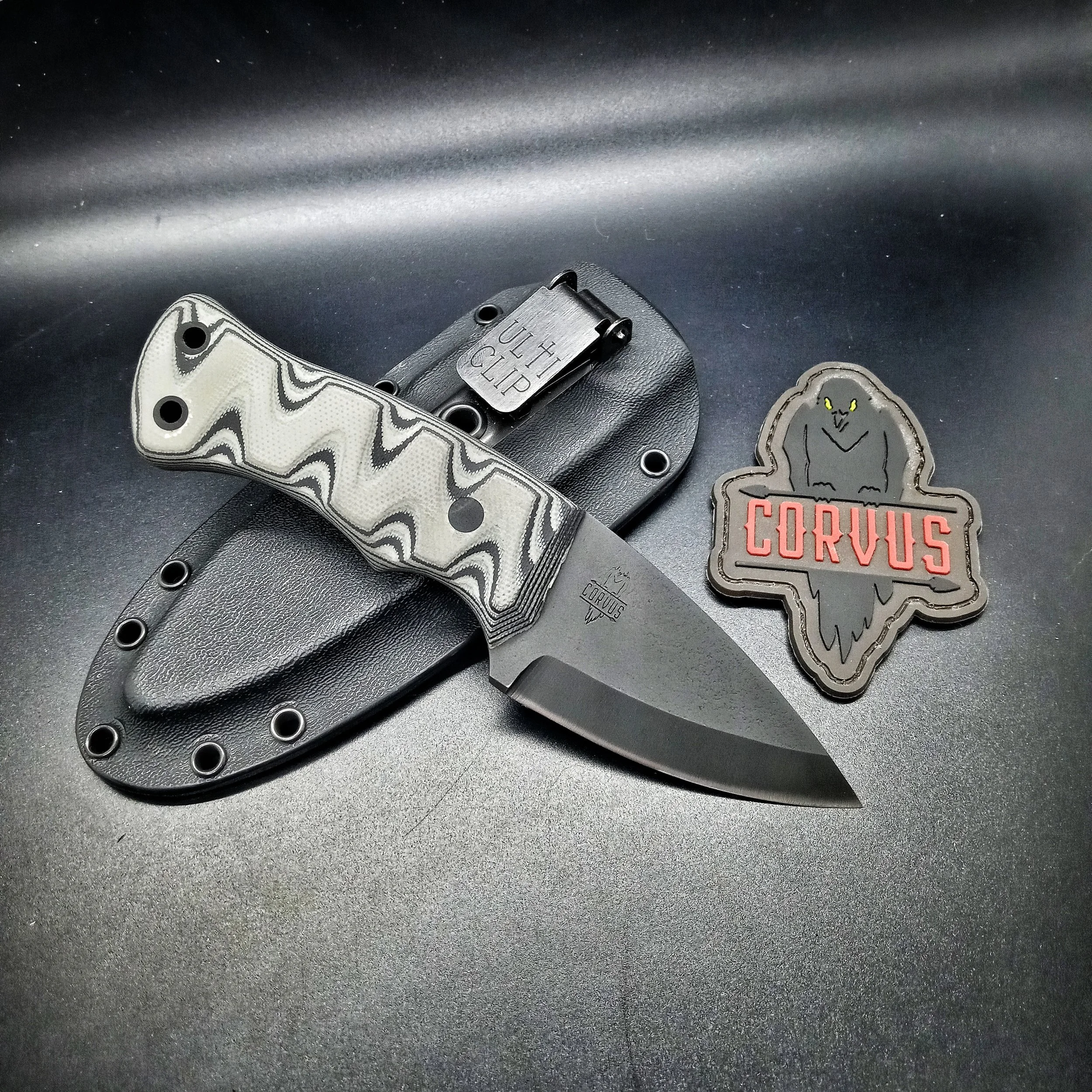 A knife resting on its sheath next to a patch.