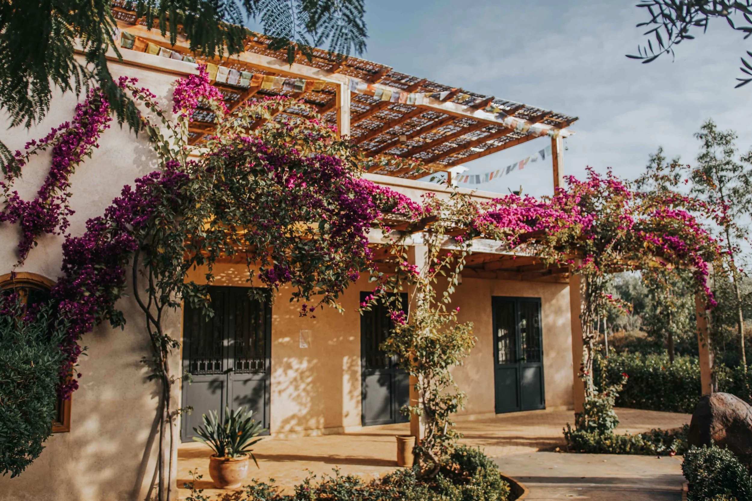 Guest rooms beneath a bougainvillea-covered terrace at Bab Zouina, Morocco