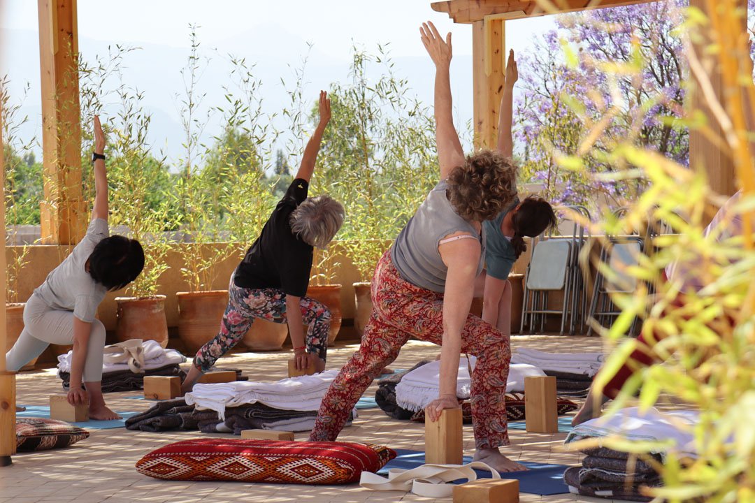 Women practising gentle yoga on a rooftop terrace at Bab Zouina