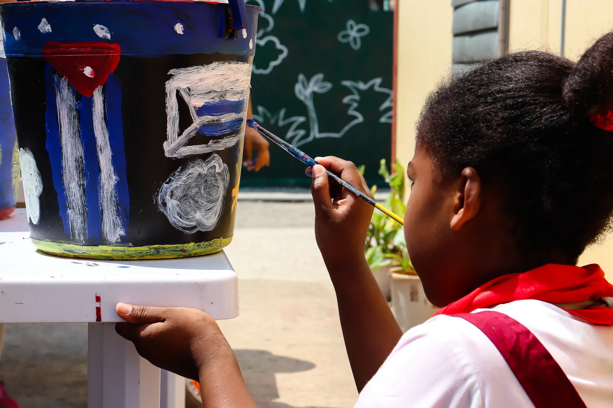 Children design and paint planting buckets whilst learning about the production and recycling of plastics in Cuba. Photo: Riera Studio