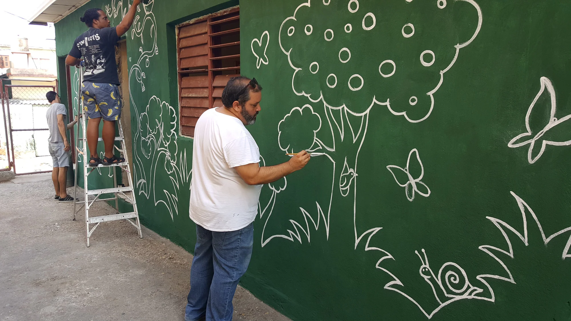 Samuel Riera and friends paint the courtyard of the primary school in Havana that participated in the Picturing Climate project. Photo: Riera Studio