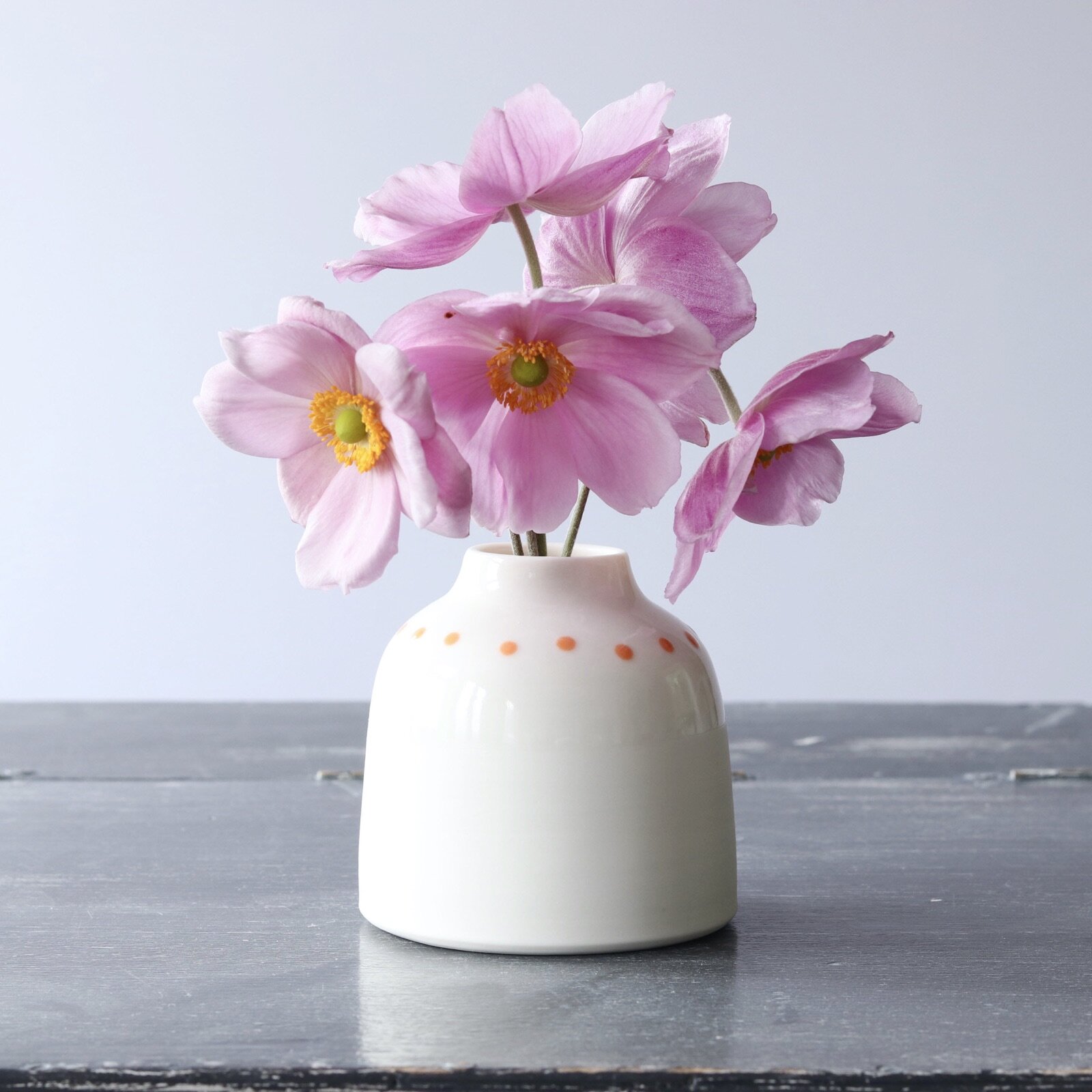 Handmade wheel thrown porcelain bud vase with orange or blue spots by penny spooner ceramics