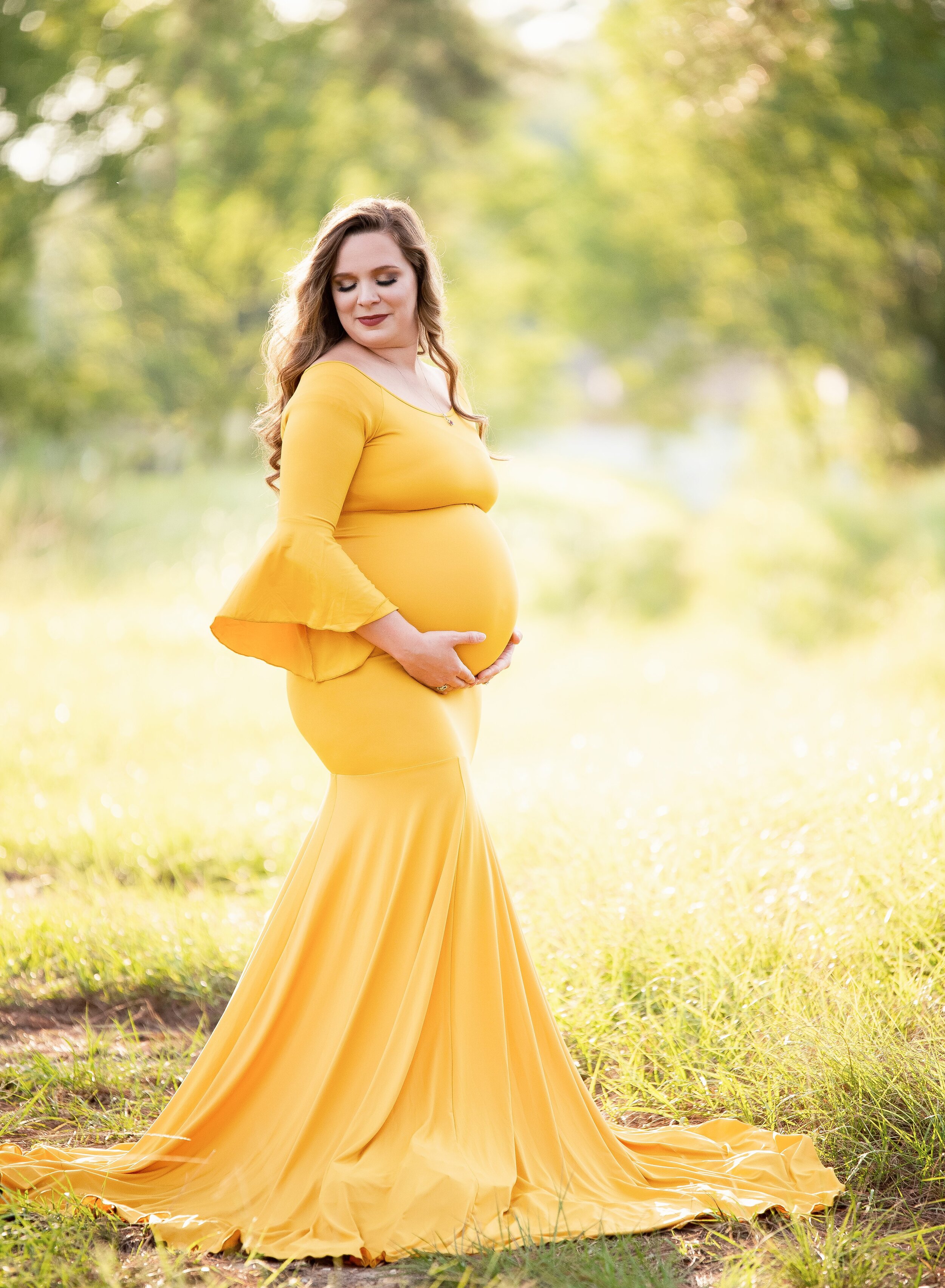 Pregnant mom in yellow gown looking over her shoulder in Crosby, TX