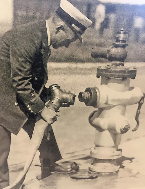 Pictured is Battalion Chief Harry Lucas demonstrating the hydrant fitting, the Lucas, he developed it for the Long Beach Fire Department in the late 1920’s.