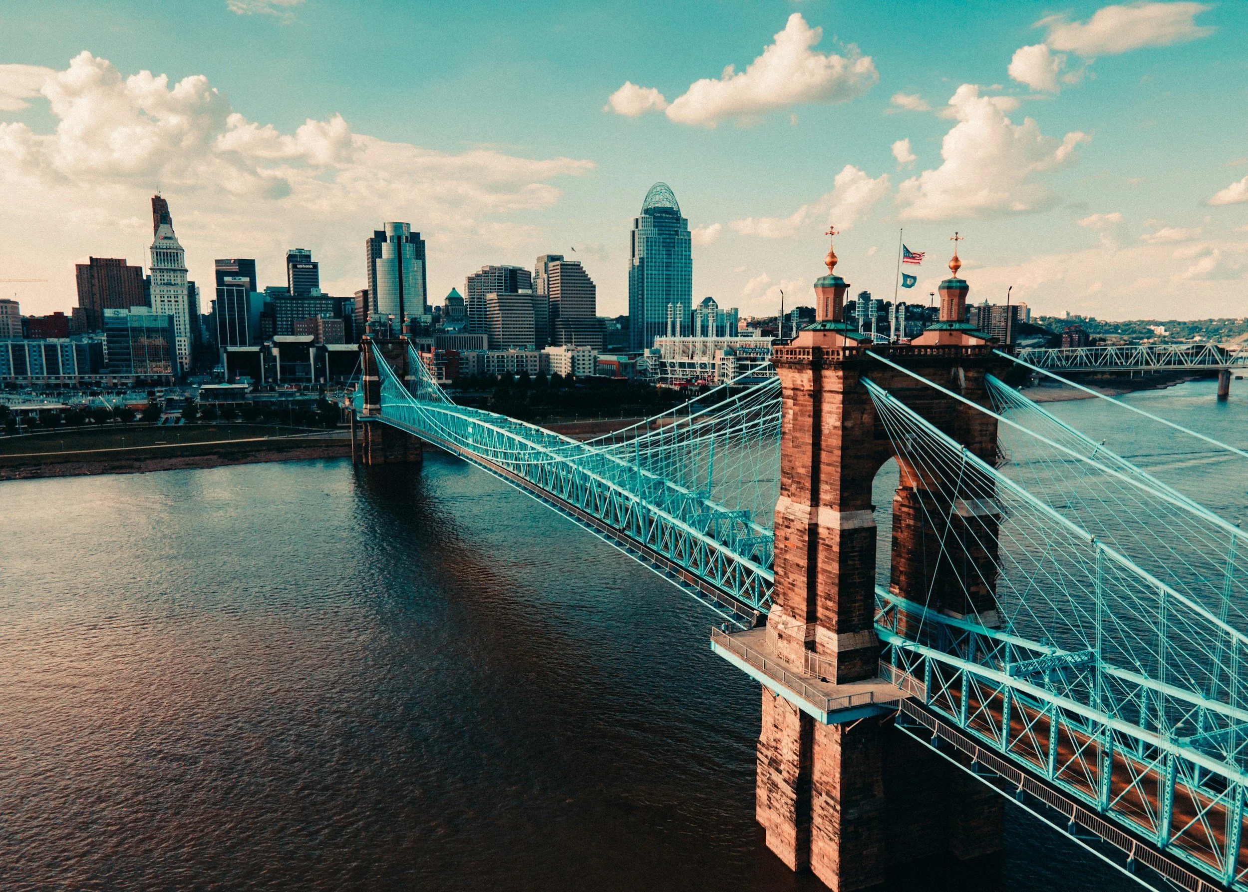 Downtown Cincinnati, OH skyline with the historic Roebling Suspension Bridge over the Ohio River
