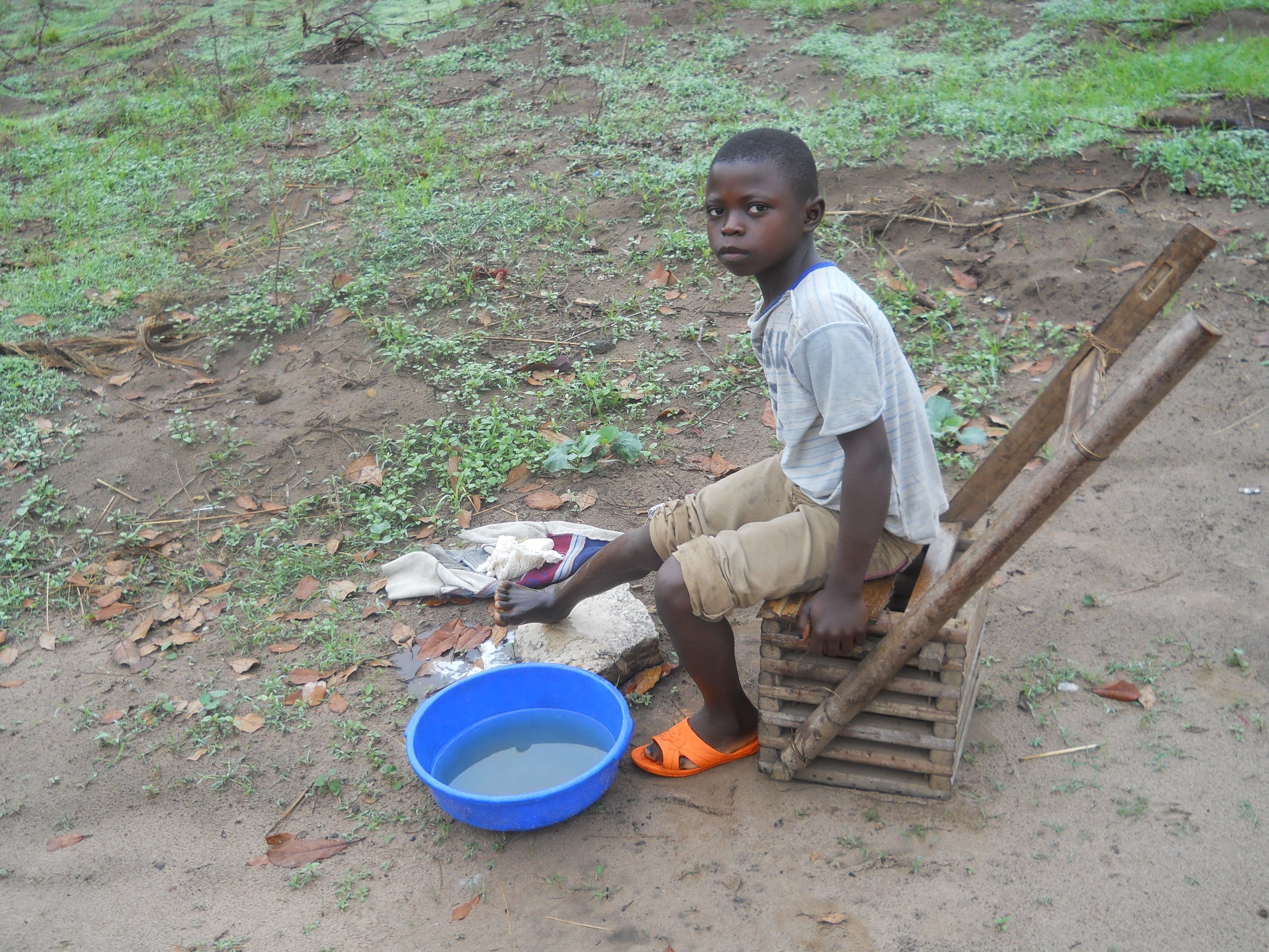 A boy using collected rain water to wash before school2.JPG
