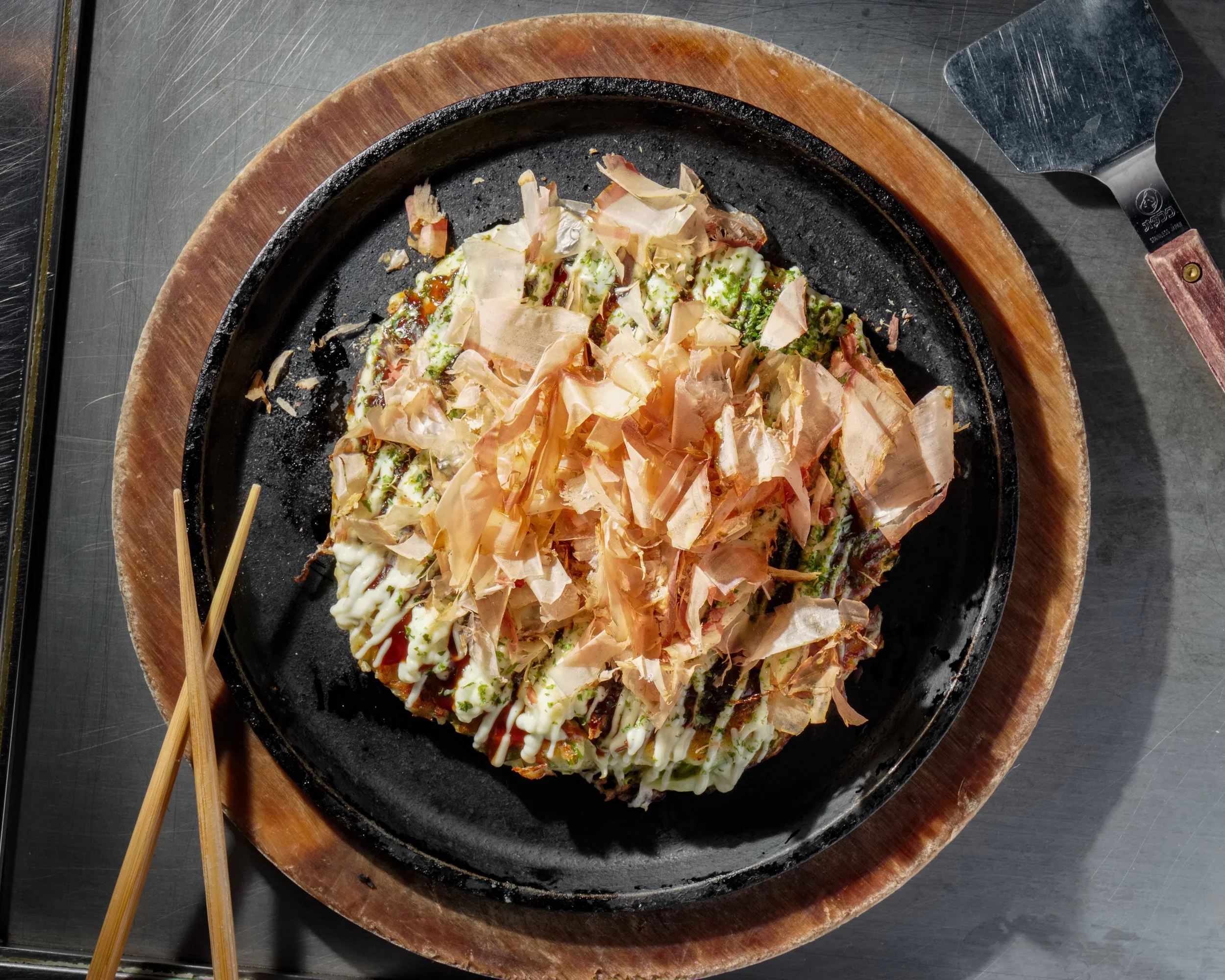 a plate of authentic japanese okonomiyaki pancake from gaijin in Chicago's west loop offered during happy hour