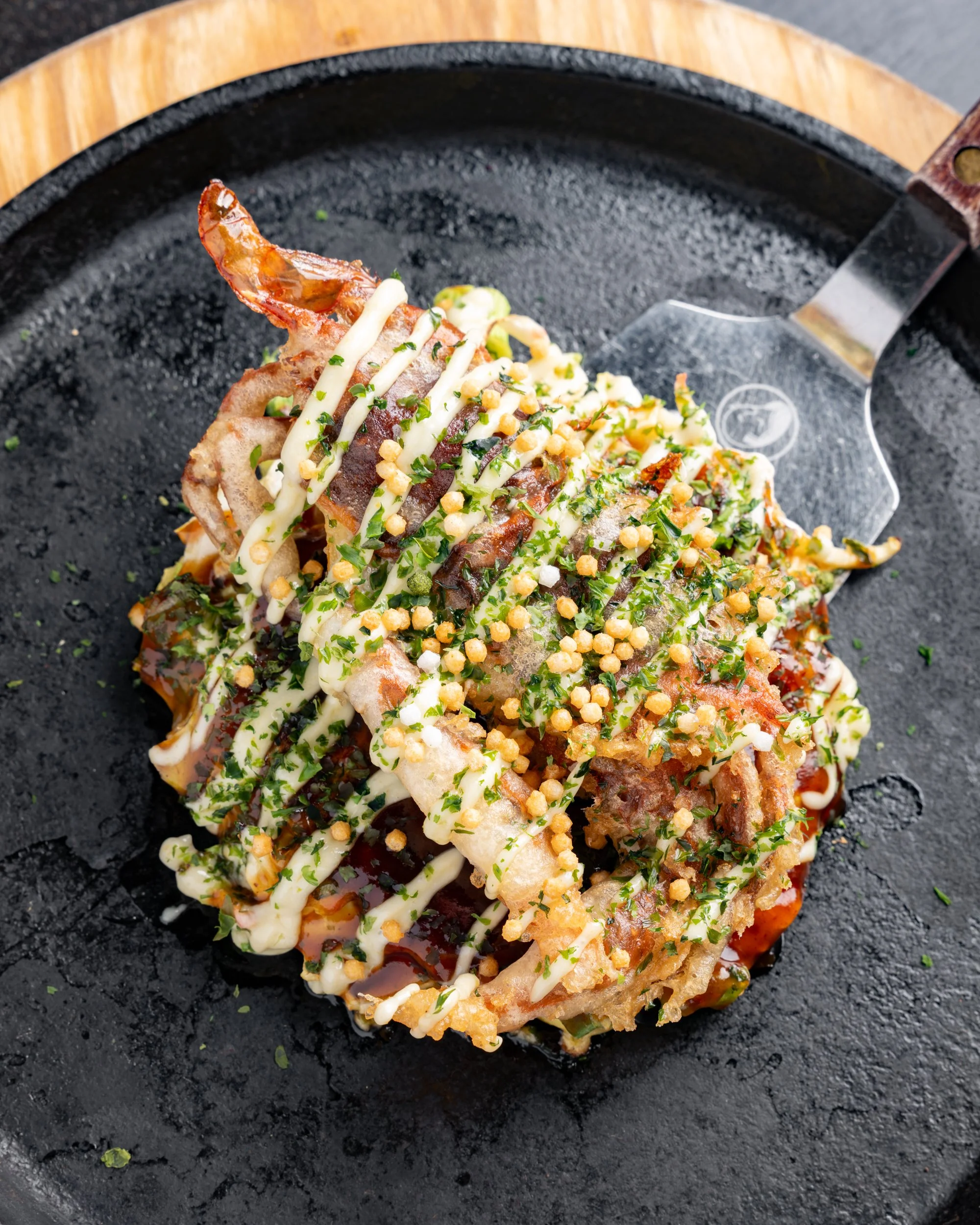 okonomiyaki japanese pancake topped with select protein, mayo drizzle and okonomiyaki sauce at gaijin chicago