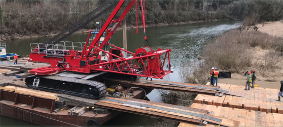 The 300-ton capacity crane crawls its way off the barge to the landing site
